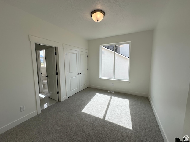 287 E 1150 N Unit 73, Salem, UT 84653 - unfurnished bedroom with carpet, connected bathroom, a textured ceiling, and a closet