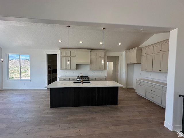 287 E 1150 N Unit 73, Salem, UT 84653 - kitchen featuring light wood finished floors, recessed lighting, a kitchen island with sink, pendant lighting, and vaulted ceiling