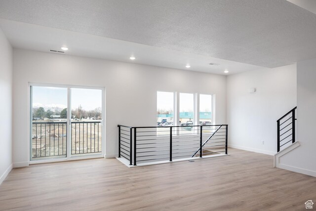 4475 S 500 E Unit 62, Millcreek, UT 84107 - spare room featuring light wood-style flooring, healthy amount of natural light, recessed lighting, and a textured ceiling