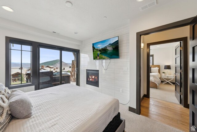 4186 Fairway Ln Unit G6, Park City, UT 84098 - bedroom with a tiled fireplace, visible vents, wood finished floors, and baseboards