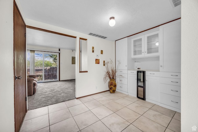 4169 S Village Ln Unit A, Taylorsville, UT 84129 - kitchen featuring glass insert cabinets, visible vents, white cabinets, and light colored carpet