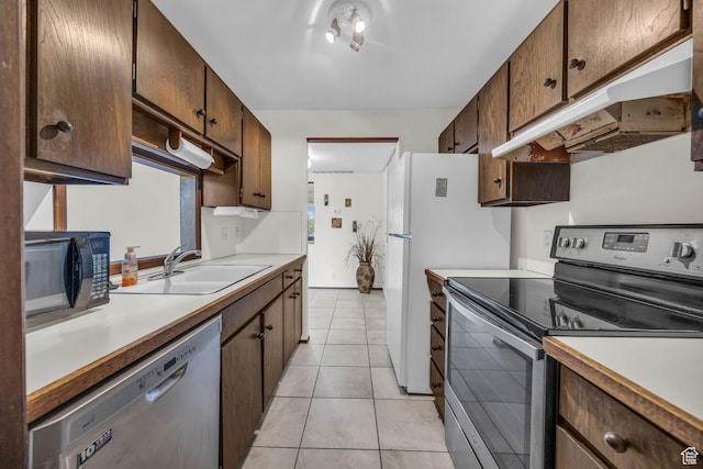 4169 S Village Ln Unit A, Taylorsville, UT 84129 - kitchen with light tile patterned floors, stainless steel appliances, under cabinet range hood, light countertops, and a sink