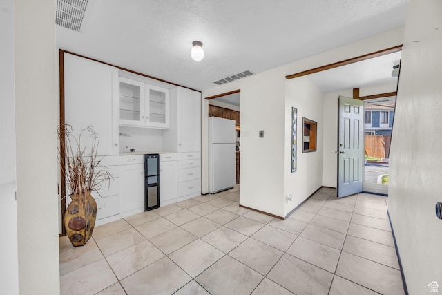 4169 S Village Ln Unit A, Taylorsville, UT 84129 - kitchen featuring visible vents, glass insert cabinets, white cabinets, and freestanding refrigerator