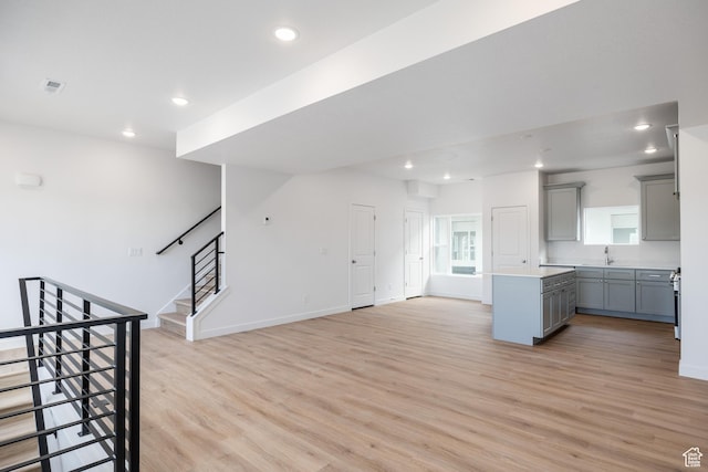 4479 S 500 E Unit 65, Millcreek, UT 84107 - unfurnished living room with light wood-style floors, recessed lighting, stairs, and a sink