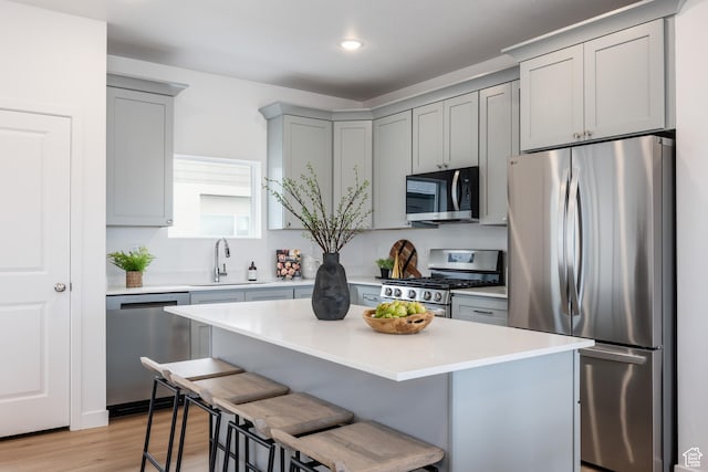 4479 S 500 E Unit 65, Millcreek, UT 84107 - kitchen with a breakfast bar, stainless steel appliances, light countertops, a sink, and gray cabinetry