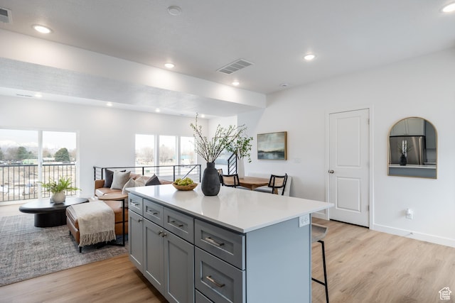 4479 S 500 E Unit 65, Millcreek, UT 84107 - kitchen with a breakfast bar area, visible vents, light wood-style flooring, gray cabinetry, and freestanding refrigerator