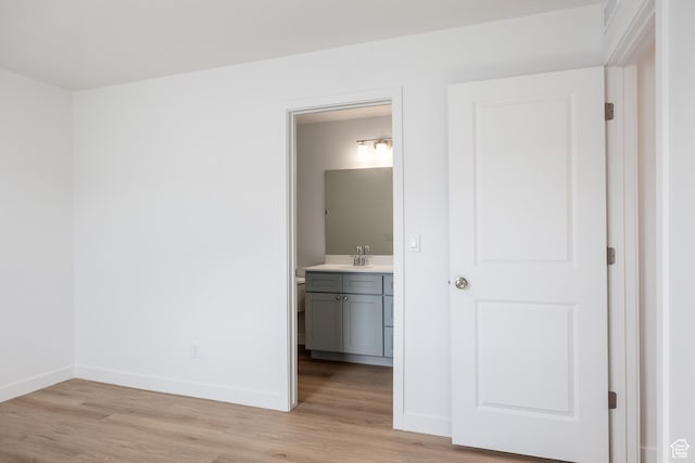 4479 S 500 E Unit 65, Millcreek, UT 84107 - unfurnished bedroom featuring a sink, baseboards, ensuite bath, and light wood-type flooring