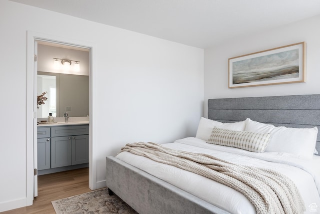 4479 S 500 E Unit 65, Millcreek, UT 84107 - bedroom featuring light wood-style floors, connected bathroom, and a sink