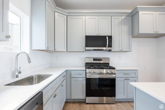 4479 S 500 E Unit 65, Millcreek, UT 84107 - kitchen featuring light wood-type flooring, appliances with stainless steel finishes, light countertops, and a sink