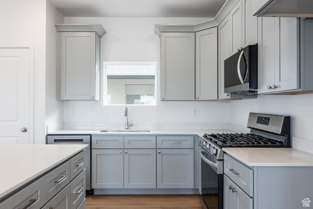 4479 S 500 E Unit 65, Millcreek, UT 84107 - kitchen featuring gray cabinets, wood finished floors, stainless steel appliances, light countertops, and a sink