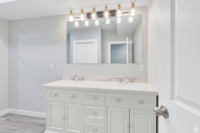 4867 N Canaan Peak Dr W, Eagle Mountain, UT 84005 - bathroom featuring double vanity, baseboards, and wood finished floors
