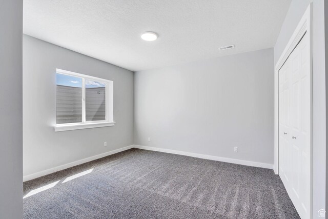 4867 N Canaan Peak Dr W, Eagle Mountain, UT 84005 - unfurnished bedroom with carpet floors, baseboards, a closet, and a textured ceiling