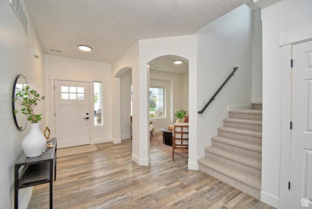 2041 S 750 E, Lehi, UT 84043 - foyer entrance featuring visible vents, baseboards, arched walkways, light wood-type flooring, and stairs