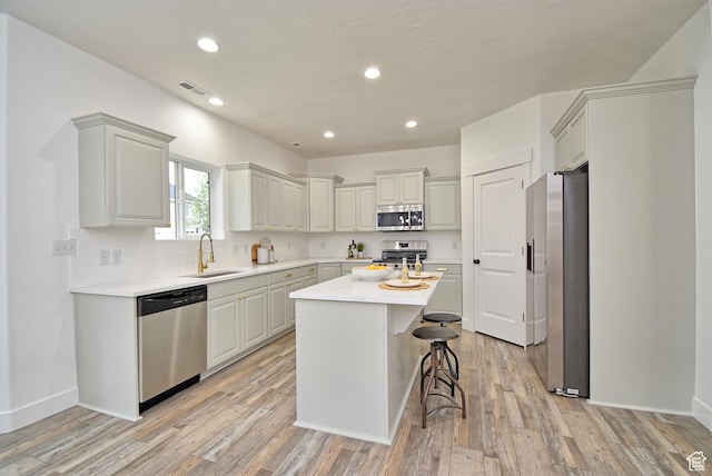 2041 S 750 E, Lehi, UT 84043 - kitchen featuring light wood-style floors, appliances with stainless steel finishes, light countertops, a kitchen island, and a sink