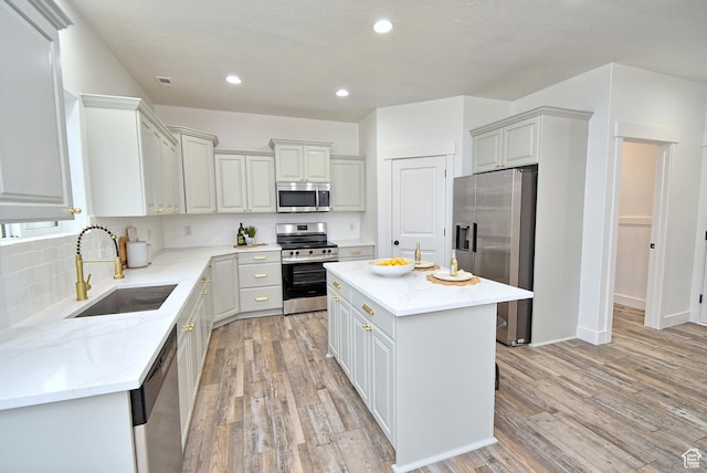 2041 S 750 E, Lehi, UT 84043 - kitchen with light wood finished floors, a sink, a center island, light stone counters, and appliances with stainless steel finishes