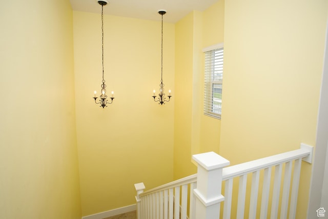 stairs featuring a chandelier