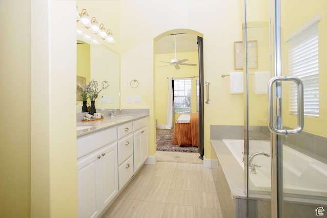 ensuite bathroom with double vanity, a bath, and a shower with door