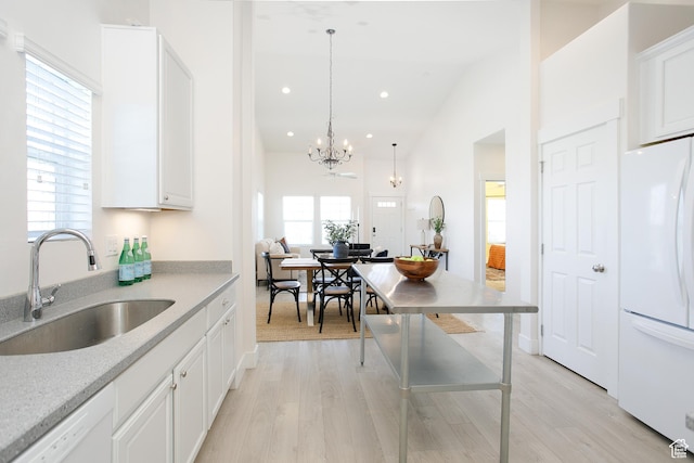 kitchen featuring white appliances, a sink, a chandelier, light wood-style flooring, and recessed lighting