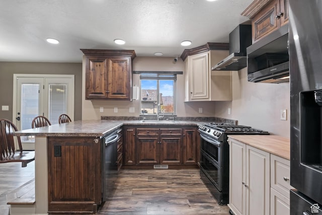 680 N 980 W, Tremonton, UT 84337 - kitchen with a sink, dark wood-style flooring, a peninsula, wall chimney range hood, and appliances with stainless steel finishes