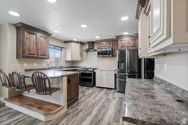 680 N 980 W, Tremonton, UT 84337 - kitchen with light wood-style floors, wall chimney exhaust hood, appliances with stainless steel finishes, and a peninsula