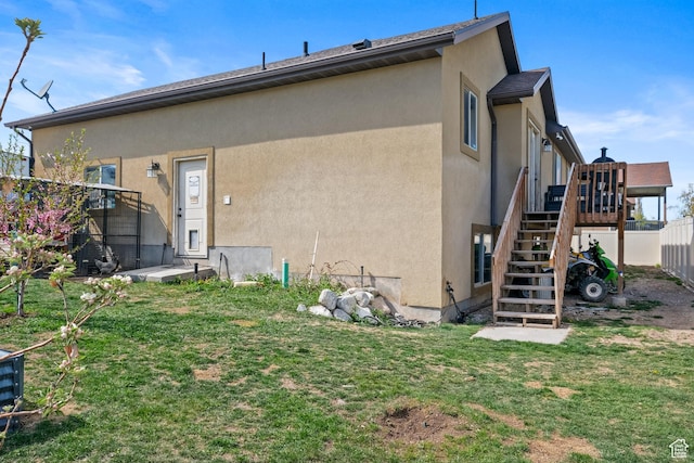 680 N 980 W, Tremonton, UT 84337 - back of property featuring a wooden deck, a lawn, stairs, stucco siding, and fence