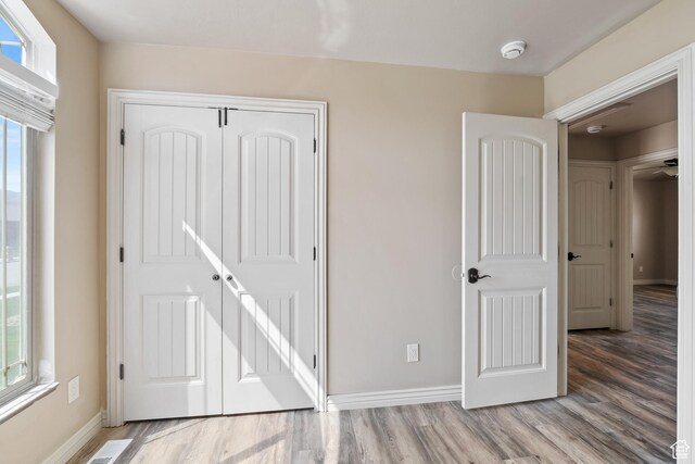 680 N 980 W, Tremonton, UT 84337 - unfurnished bedroom featuring baseboards, wood finished floors, and multiple windows