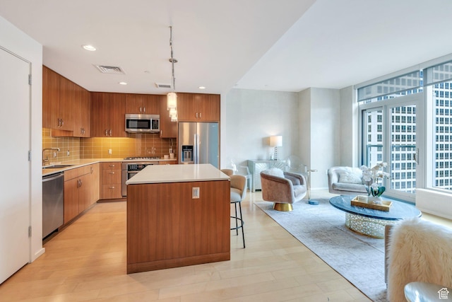 35 E 100 S Unit 1504, Salt Lake City, UT 84111 - kitchen featuring decorative backsplash, appliances with stainless steel finishes, visible vents, a kitchen island, and light countertops