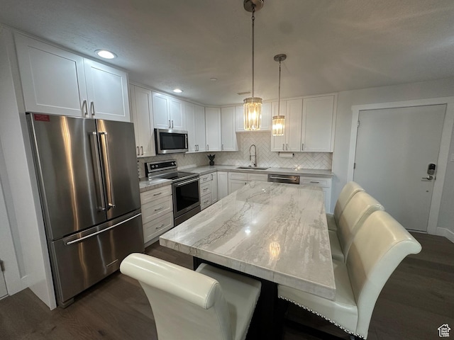 560 E S Temple St S Unit 302, Salt Lake City, UT 84102 - kitchen with tasteful backsplash, white cabinets, a sink, appliances with stainless steel finishes, and dark wood finished floors
