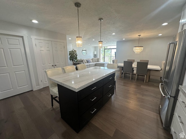 560 E S Temple St S Unit 302, Salt Lake City, UT 84102 - kitchen featuring a kitchen breakfast bar, white cabinets, freestanding refrigerator, an inviting chandelier, and dark cabinetry