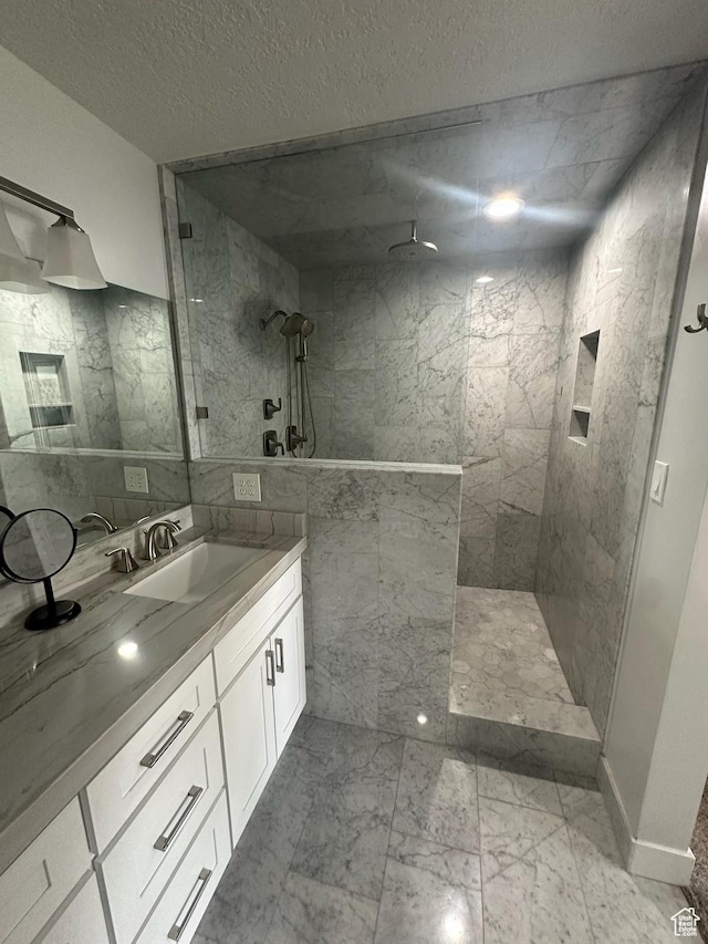 560 E S Temple St S Unit 302, Salt Lake City, UT 84102 - bathroom featuring tile walls, a walk in shower, vanity, and marble finish floor
