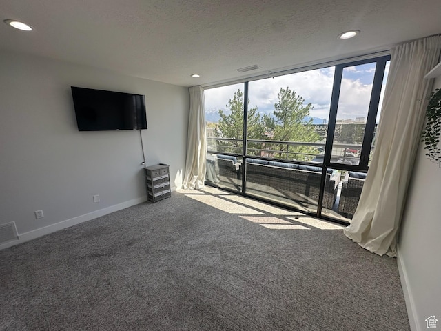 560 E S Temple St S Unit 302, Salt Lake City, UT 84102 - unfurnished living room with floor to ceiling windows, visible vents, carpet flooring, and baseboards
