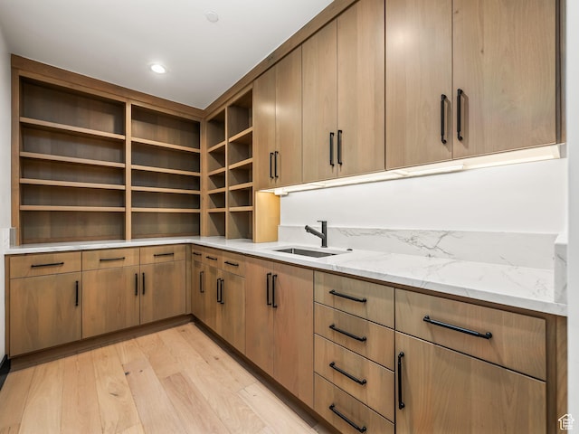 897 S Summit Creek Dr, Woodland Hills, UT 84653 - kitchen with light stone countertops, open shelves, light wood-style floors, and a sink