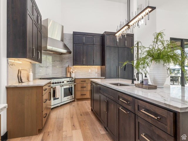 897 S Summit Creek Dr, Woodland Hills, UT 84653 - kitchen with double oven range, light stone counters, a sink, light wood-type flooring, and wall chimney exhaust hood