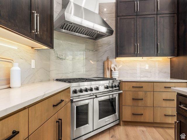 897 S Summit Creek Dr, Woodland Hills, UT 84653 - kitchen featuring tasteful backsplash, light stone counters, wall chimney range hood, light wood finished floors, and range with two ovens