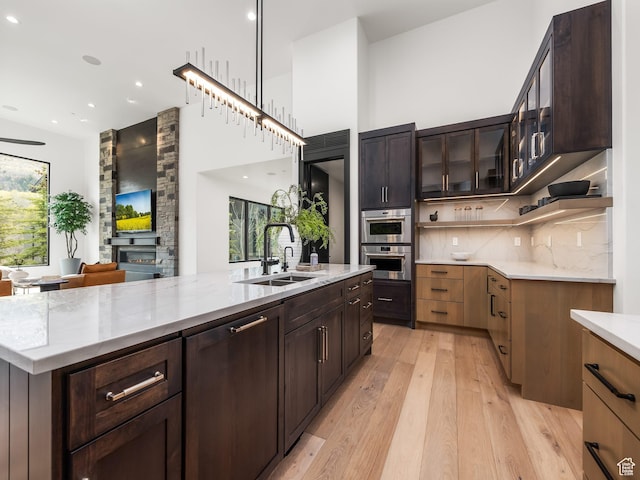 897 S Summit Creek Dr, Woodland Hills, UT 84653 - kitchen with light wood-type flooring, a fireplace, a sink, and plenty of natural light