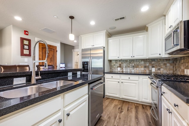 13386 N Alexis Dr, Kamas, UT 84036 - kitchen with appliances with stainless steel finishes, white cabinets, light wood finished floors, and recessed lighting