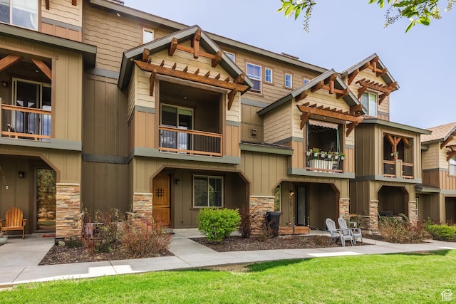 13386 N Alexis Dr, Kamas, UT 84036 - view of front of house featuring a balcony, stone siding, and a front lawn