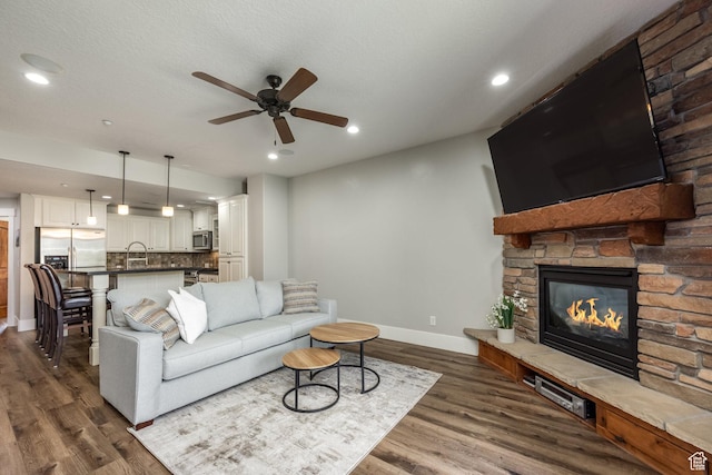 13386 N Alexis Dr, Kamas, UT 84036 - living area with ceiling fan, dark wood-style flooring, a stone fireplace, and recessed lighting