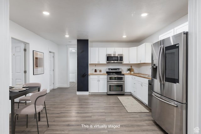 233 Patterson St, Ogden, UT 84401 - kitchen with white cabinets, a sink, stainless steel appliances, recessed lighting, and light wood finished floors