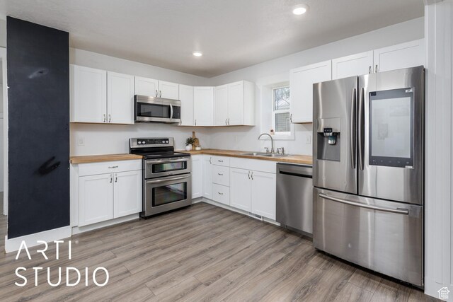 233 Patterson St, Ogden, UT 84401 - kitchen with wooden counters, stainless steel appliances, light wood-type flooring, and a sink