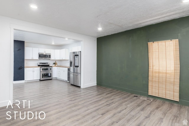 233 Patterson St, Ogden, UT 84401 - kitchen featuring recessed lighting, light wood-style floors, appliances with stainless steel finishes, light countertops, and white cabinetry