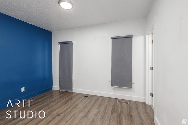 233 Patterson St, Ogden, UT 84401 - spare room with a textured ceiling, wood finished floors, visible vents, and baseboards