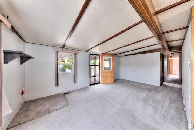 1575 Rocky Rd, Moab, UT 84532 - unfurnished living room with carpet floors, beam ceiling, and a textured ceiling
