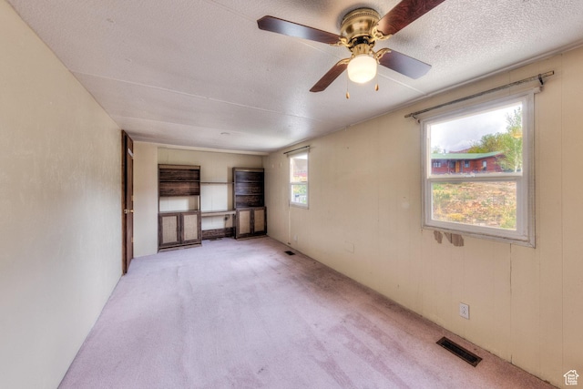 1575 Rocky Rd, Moab, UT 84532 - spare room featuring a textured ceiling, ceiling fan, visible vents, and light carpet