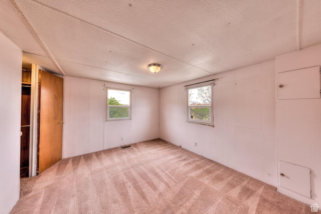 1575 Rocky Rd, Moab, UT 84532 - unfurnished bedroom featuring carpet flooring, a textured ceiling, and multiple windows