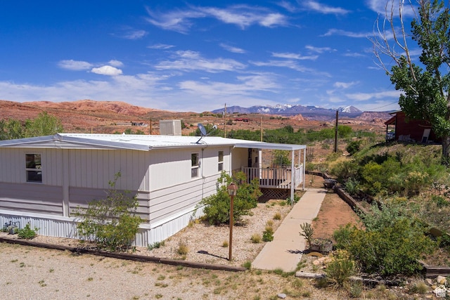 view of side of home featuring a porch and a mountain view