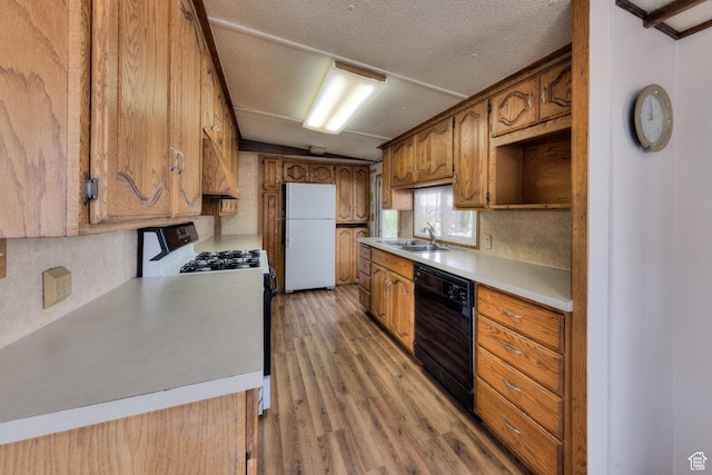 1575 Rocky Rd, Moab, UT 84532 - kitchen with freestanding refrigerator, lofted ceiling, light wood-style floors, black dishwasher, and gas range
