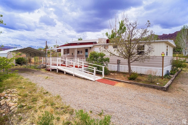 1575 Rocky Rd, Moab, UT 84532 - back of property with covered porch, dirt driveway, and a carport