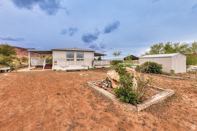 1575 Rocky Rd, Moab, UT 84532 - rear view of house featuring fence, a wooden deck, and an outbuilding