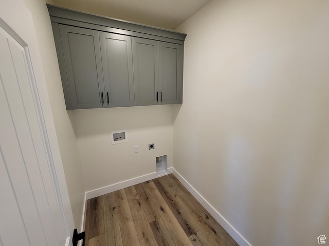 laundry area featuring hookup for an electric dryer, baseboards, hookup for a washing machine, light wood-type flooring, and cabinet space